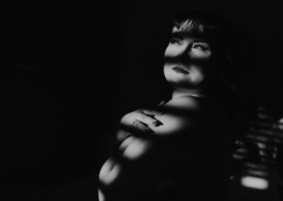 Schöne schwarzhaarige Frau auf schwarz-weiß-Fotografie bei ihrem sinnlichen Fotoshooting.
