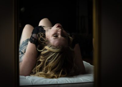 Blonde Frau liegend auf dem Bett bei ihrem Boudoir-Shooting