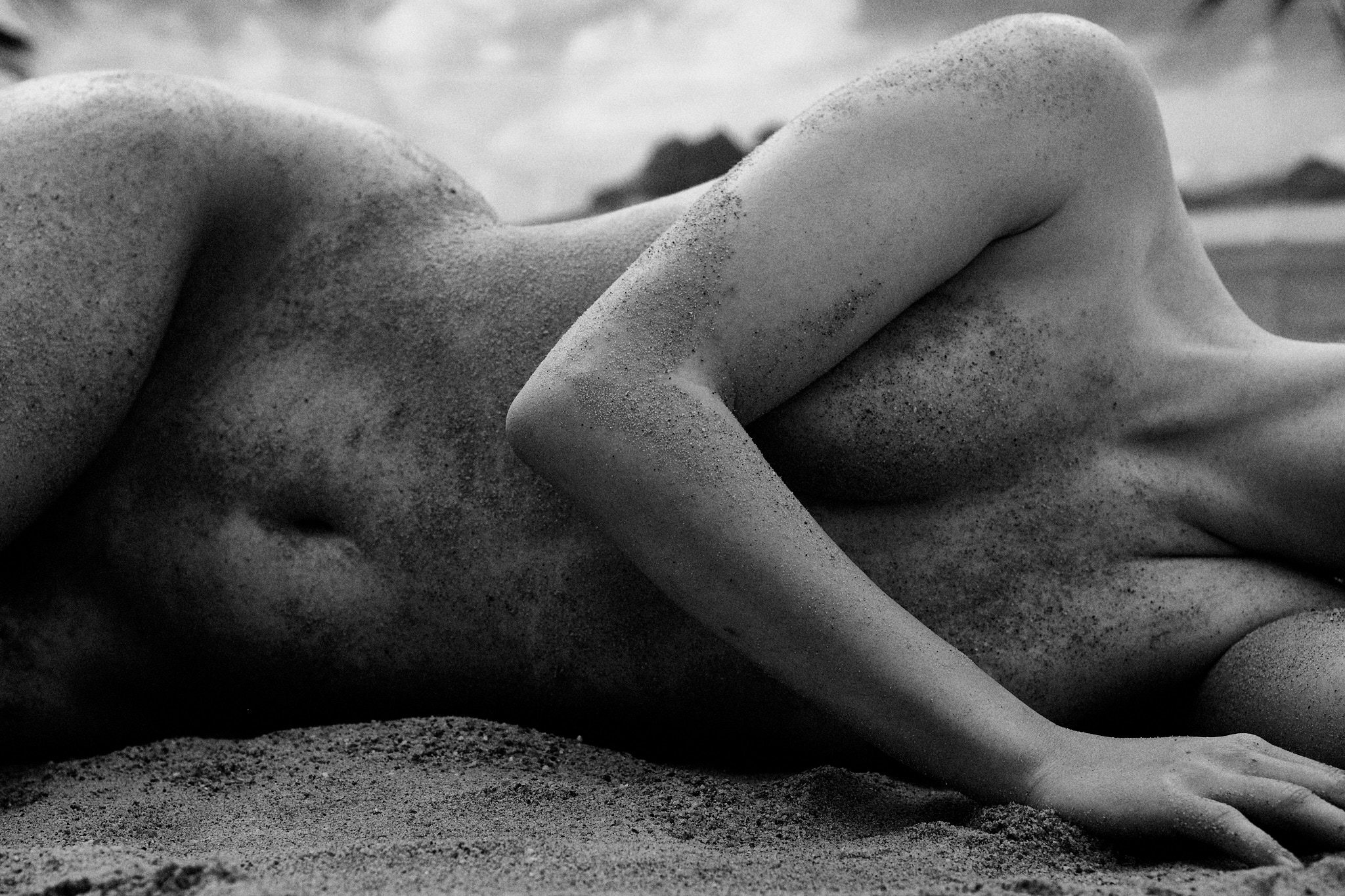 Frau im Sand liegend Akt fotografiert